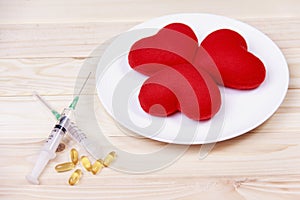 Concept red heart on plate with syringe and stimulant on wood b