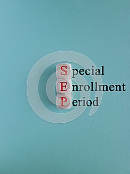 Concept red words SEP special enrollment period on wooden cubes on a beautiful blue background.