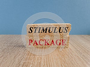 Concept red words stimulus package on wooden blocks. Beautiful wooden table, blue background. Copy space