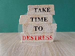 Concept red words Take time to destress on brick blocks. Beautiful wooden table, green background.