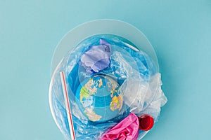The concept of reducing plastic bags use: Modeled globes are sunk in many white plastic bags. Meaning, plastic bags are about to