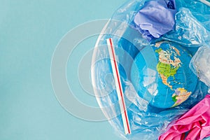 The concept of reducing plastic bags use: Modeled globes are sunk in many white plastic bags. Meaning, plastic bags are about to photo