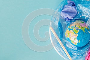 The concept of reducing plastic bags use: Modeled globes are sunk in many white plastic bags. Meaning, plastic bags are about to