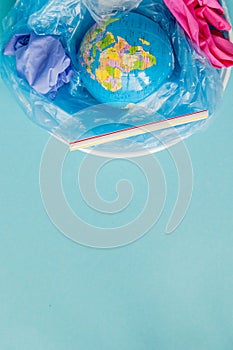 The concept of reducing plastic bags use: Modeled globes are sunk in many white plastic bags. Meaning, plastic bags are about to