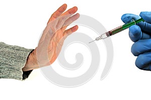 Concept of refusal of vaccination with a hand opposing a syringe close-up on a white background