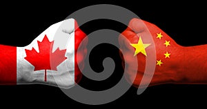 Concept of relations/conflict between Canada and China symbolized by two opposed clenched fists