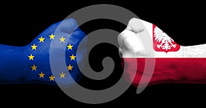 Concept of relations/conflict between Poland and the European Union symbolized by two opposed clenched fists photo