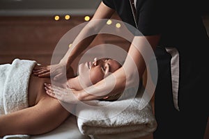 Lady having decollete massage in spa salon photo