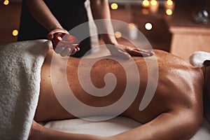 Massage therapist pour essential oil out from bowl