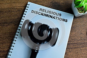 Concept of Religious Discrimination write on book with gavel isolated on Wooden Table