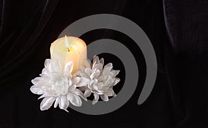 The concept of remembrance, funerals, and condolences. Candle and white flowers, free space for text