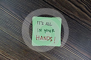 Concept of It`s All In Your Hands! write on sticky notes isolated on Wooden Table