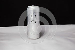 Concept of sad man. melancholy emoticon on aluminium can, Emoji with sorry face. On black background