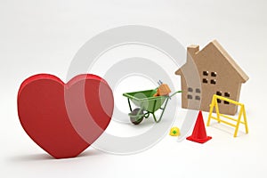 Concept of safety image. Red heart shaped wood, house and construction tools of miniature on white back ground.