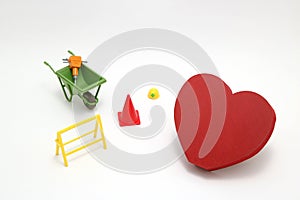 Concept of safety image. Red heart shaped wood, house and construction tools of miniature on white back ground.