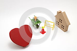 Concept of safety image. Red heart shaped wood, house and construction tools of miniature on white back ground.