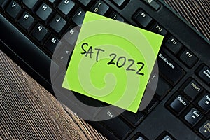 Concept of Sat 2022 - Scholastic Asessment Test 2022 write on sticky notes isolated on Wooden Table