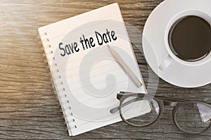 Concept Save the Date message on notebook with glasses, pencil a