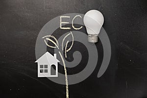 Concept for saving energy, eco-friendly, global warming. Creative top view flat lay of LED light bulb, drawing leaves, paper house