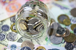 Concept of saving money, money in a glass jar, on the background of banknotes of different countries