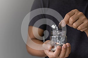 The concept of saving money or savings, investment, Finance, business. Businessman holding a glass jar piggy bank with an icon
