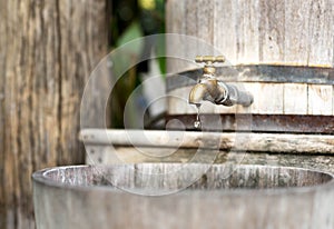 Concept saving water wooden water tank with golden tap and in s