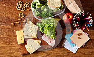 Concept of school lunch break with healthy lunch box and school supplies on wooden desk, selective focus.