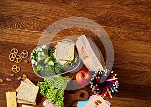 Concept of school lunch break with healthy lunch box and school supplies on wooden desk, selective focus.