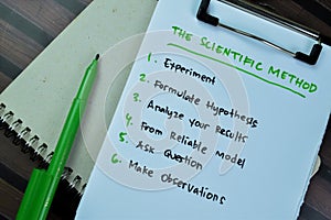 Concept of The Scientific Method write on paperwork isolated on Wooden Table