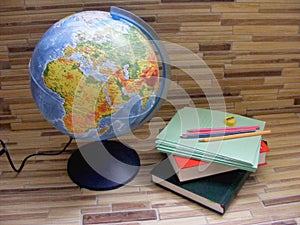 Concept scool, globe amd books on wooden background photo