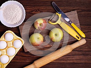 The concept of seasonal Apple baking. Ingredients for Apple pie on a rustic wooden table.
