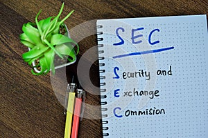 Concept of SEC - Security and Exchange Commision write on book isolated on Wooden Table