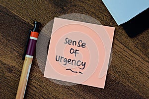 Concept of Sense of Urgency write on sticky notes isolated on Wooden Table