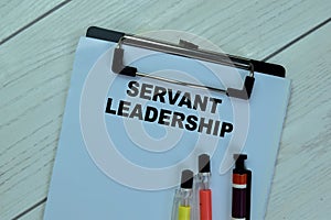 Concept of Servant Leadership write on paperwork isolated on Wooden Table