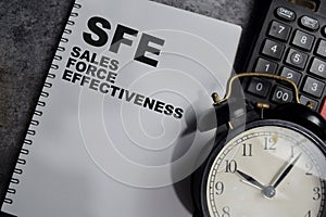 Concept of SFE - Sales Force Effectiveness write on book isolated on Wooden Table