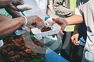 The concept of sharing food to hungry and starving people : Volunteers are handing out food to the poor