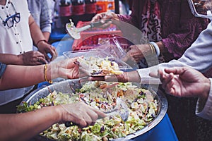 The concept of sharing food to hungry and starving people : Volunteers are handing out food to the poor