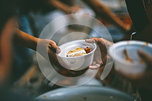 The concept of sharing food to hungry and starving people : Volunteers are handing out food to the poor