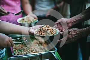 The concept of sharing food to hungry and starving people : Volunteers are handing out food to the poor