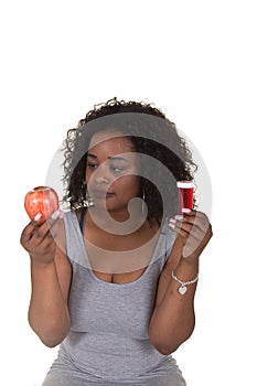 Concept shoot about health care of a woman choosing between an apple and a pill bottle