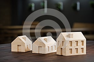 Concept shot: three differently sized wooden models of houses on an architects table