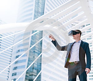 Concept Simulation Business, Smart businessman in a suit wear vr goggles with city town background..