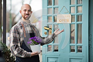 Concept of small business florist entrepreneur the charismatic man owner of the floral shop smiling large to the camera