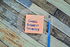 Concept of Small Business Saturday write on sticky notes isolated on Wooden Table