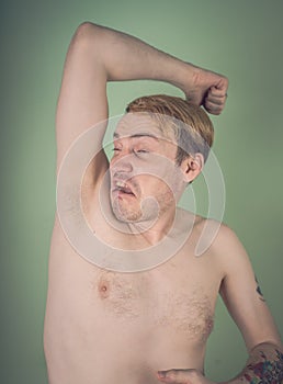 Guy sniffs his armpits