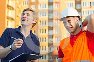 Concept, smiling group of builders in hardhats with clipboard