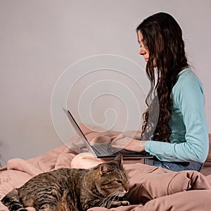 The concept of social distance and isolation. Work from home remotely over the Internet. A young woman works at home on a computer