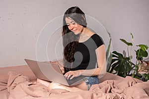 The concept of social distance and isolation. Work from home remotely over the Internet. A young woman works at home on a computer