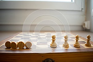 Concept of social distancing and its benefits, with four chess pawns fallen and four spread and standing