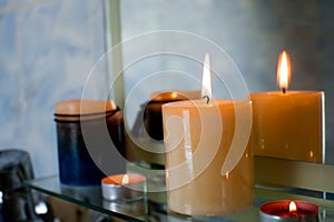 Concept of spa treatment in salon. Natural organic oil, towel, candles as decor. Atmosphere of relax, serenity and pleasure. Anti-